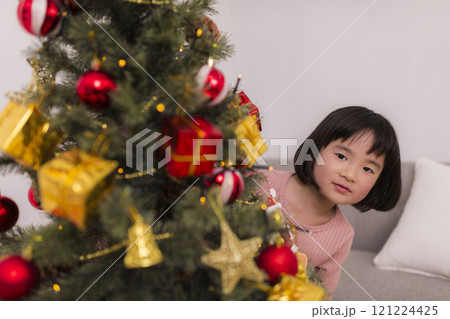 クリスマスツリーを飾りつける女の子 121224425