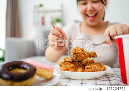 Beautiful Asian woman eating fried chicken, smiling with a happy face. 121224751
