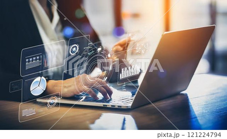 Young professional it specialist business man working on laptop pc sitting at desk in modern office space. 30s man using computer technology app for work online 121224794