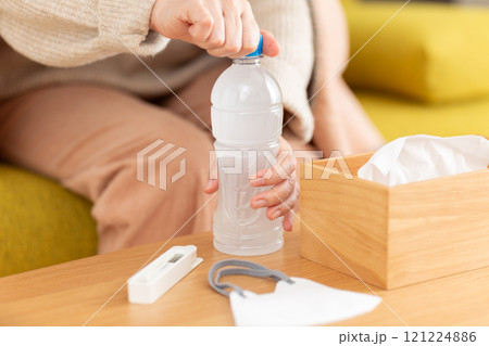 スポーツドリンクで水分補給をする風邪を引いたミドル〜シニア女性 121224886