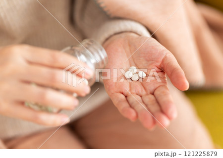 錠剤の薬を飲むミドル〜シニア女性 121225879