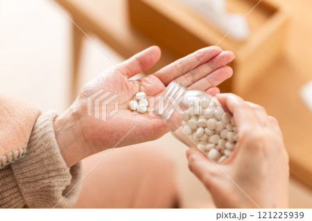錠剤の薬を飲むミドル〜シニア女性 121225939