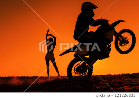 Silhouette of a man on a motorbike on the back whee Silhouette of a man on a motorbike on the back whee 121226833
