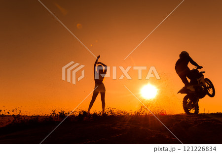 Silhouette of a man on a motorbike on the back whee Silhouette of a man on a motorbike on the back whee 121226834