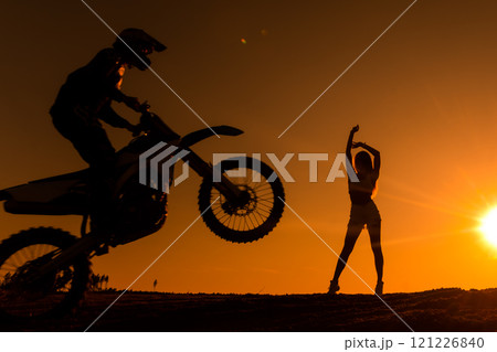 Silhouette of a man on a motorbike on the back whee Silhouette of a man on a motorbike on the back whee 121226840