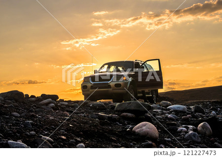 SUV off-road vehicle on foothill rocky off-road at dawn. Road trip, wilderness adventure, expedition or extreme 4x4 vehicle journey, copy space. 121227473