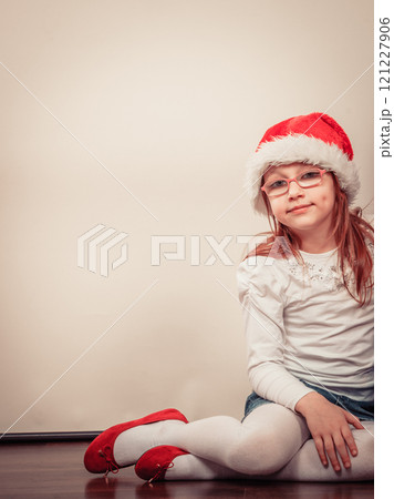 Christmas girl in santa hat festive outfit 121227906