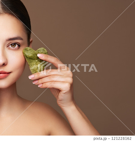 Young woman doing scrapping massage facial skin 121228162