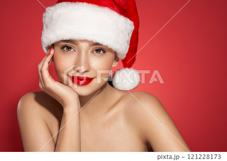Girl in Santa Hat over holiday red Background 121228173