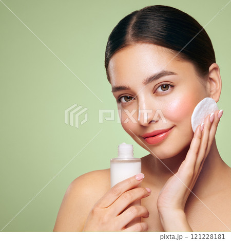 Young woman cleansing face with cosmetic milk Young woman cleansing face with cosmetic milk 121228181