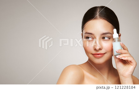 Woman holding a cosmetic jar of oil serum 121228184