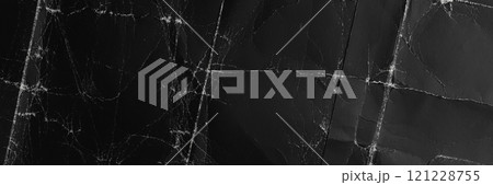 Wrinkled crumpled black paper with worn texture. Distressed folds on dark abstract cardboard background surface. Top view Wrinkled crumpled black paper with worn texture. Distressed folds on dark abstract cardboard background surface. Top view 121228755