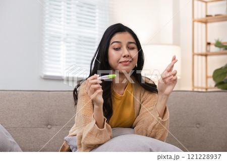 Exciting moment woman holds pregnancy test cozy living room emotional scene warm lighting hopeful outlook on future 121228937