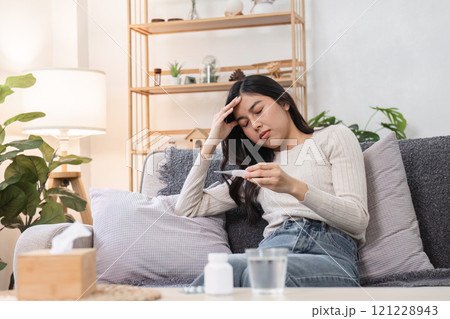 Sick woman monitoring health cozy living room emotional well-being indoor setting close-up view unwell condition 121228943