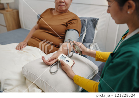Caregiver Checking Pressure Of Senior Woman Caregiver Checking Pressure Of Senior Woman 121229324