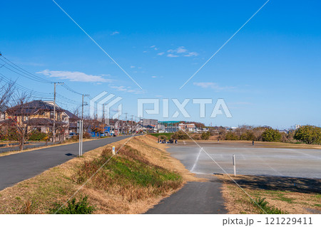 青空と川沿いのサイクリングロードと住宅街 121229411