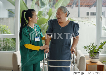Social Worker Helping Senior Woman To Walk 121229435