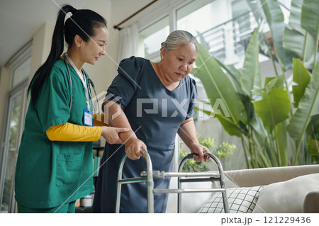 Senior Woman Walking With The Help Of Nurse Senior Woman Walking With The Help Of Nurse 121229436
