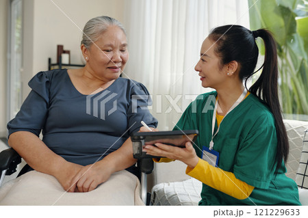 Nurse Making Appointment Online On Tablet PC 121229633