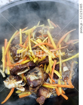 cooking lamb pilaf in a cauldron over a fire cooking lamb pilaf in a cauldron over a fire 121231485