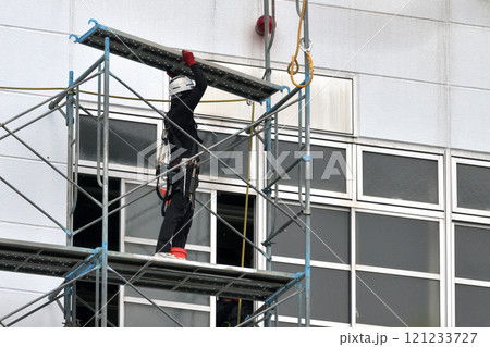 工事現場　工場外壁改修工事　仮設足場組み立て作業風景 121233727