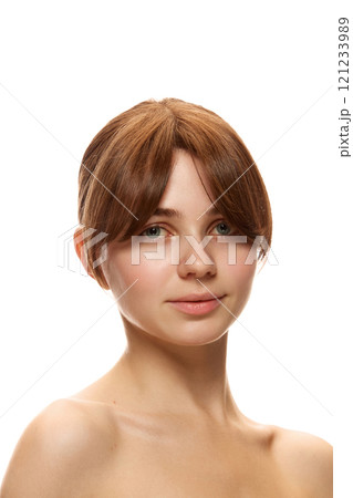 Natural blushing. Portrait of beautiful young woman with spotless, well-kept skin without makeup, looking at camera against white studio background 121233989