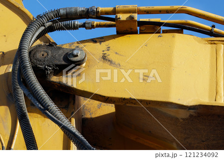 Hydraulic Excavator Arm Detail with Hoses and Metal Components Hydraulic Excavator Arm Detail with Hoses and Metal Components 121234092