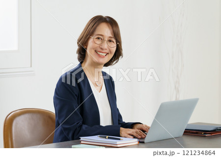 デスクでノートパソコンを使って作業するミドルエイジの女性のポートレート 121234864
