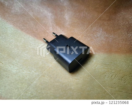 Closeup of a black super fast charging adapter on a soft background. 121235068