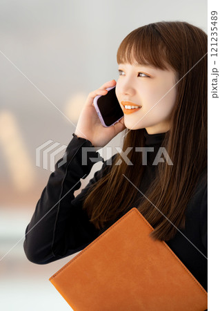 スマホで話す笑顔の女性・ビジネスウーマン 121235489