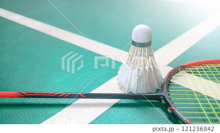 White badminton shuttlecocks and badminton rackets on green floor indoor badminton court. Concept for badminton competition and its lovers. 121236842