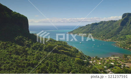 Aerial drone showing Moorea tropical island, Opunohu bay, lush vegetation, boats sailing, and turquoise water in French Polynesia. Remote wild nature paradise, exotic summer travel background 121237591