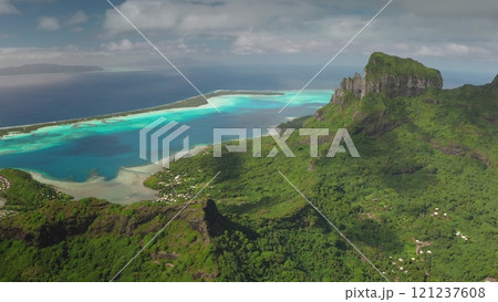 Breathtaking aerial view of Bora Bora island, French Polynesia, vibrant turquoise lagoon, lush green vegetation, and majestic mount Otemanu under a cloudy sky. Wild travel destination, remote nature Breathtaking aerial view of Bora Bora island, French Polynesia, vibrant turquoise lagoon, lush green vegetation, and majestic mount Otemanu under a cloudy sky. Wild travel destination, remote nature 121237608