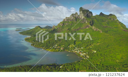 Breathtaking aerial view of Bora Bora island lagoon showing its lush green vegetation, turquoise coral reef, and majestic mount Otemanu. Aerial drone shot. French Polynesia travel tropical paradise 121237624