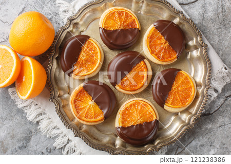 Sweet tasty cookies with candied orange and chocolate glaze close-up in a plate. Horizontal top view 121238386
