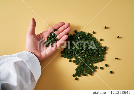 Superfood chlorella in tablet form in a woman's hand. Superfood chlorella in tablet form in a woman's hand. 121238643