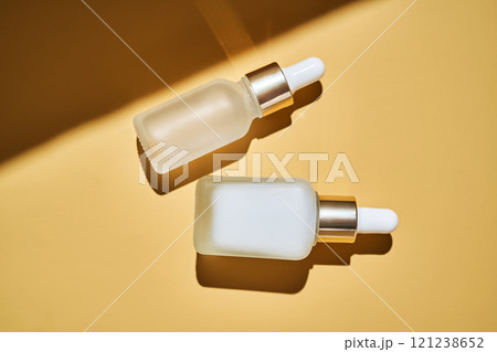 Two bottles of serum on a beige background with a beautiful shadow. Two bottles of serum on a beige background with a beautiful shadow. 121238652