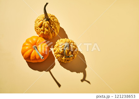 Three different decorative pumpkins on a yellow background. Three different decorative pumpkins on a yellow background. 121238653