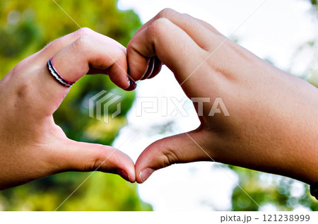 Close-up of heart-shaped hands against the sky Close-up of heart-shaped hands against the sky 121238999