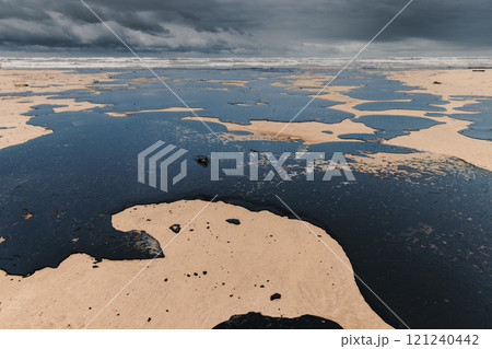 Oil spill in coastline after a tanker wreck. Fuel oil polluted beach Oil spill in coastline after a tanker wreck. Fuel oil polluted beach 121240442