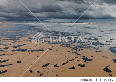 Oil in sea coastline after a tanker wreck. Oil fuel polluted sandy beach Oil in sea coastline after a tanker wreck. Oil fuel polluted sandy beach 121240445