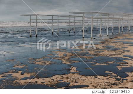 Beach and ocean are polluted with fuel oil. Beach oil spill impact, pollution, waste disposal. 121240450
