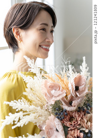 屋内で花束を持つミドル女性 屋内で花束を持つミドル女性 121241809