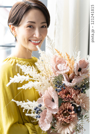 屋内で花束を持つミドル女性 屋内で花束を持つミドル女性 121241815