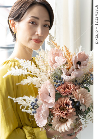 屋内で花束を持つミドル女性 屋内で花束を持つミドル女性 121241816