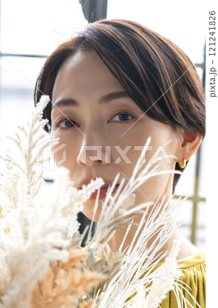 屋内で花束を持つミドル女性 121241826