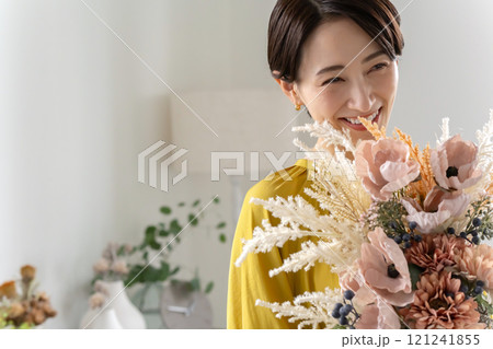 屋内で花束を持つミドル女性 121241855