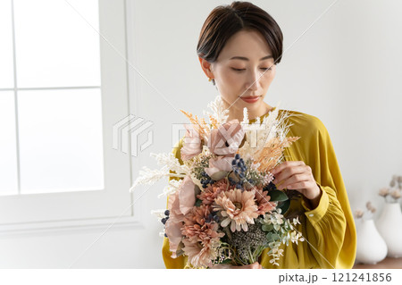 屋内で花束を持つミドル女性 屋内で花束を持つミドル女性 121241856
