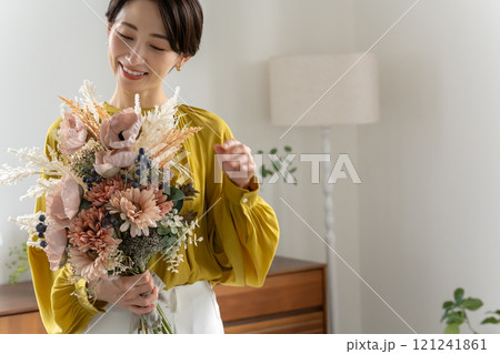 屋内で花束を持つミドル女性 屋内で花束を持つミドル女性 121241861