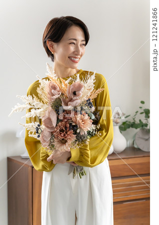 屋内で花束を持つミドル女性 屋内で花束を持つミドル女性 121241866